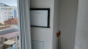 Una habitación con un ventanal grande, un radiador y una puerta.