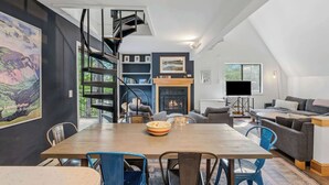 Un loft moderno con comedor, chimenea, sofá y estantería.