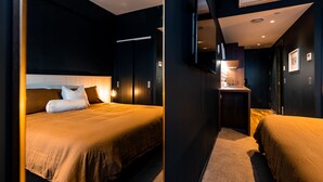 A modern hotel room with a large bed, a small kitchenette, and a walk-in closet. - The Cobbler Hotel (Wellington)