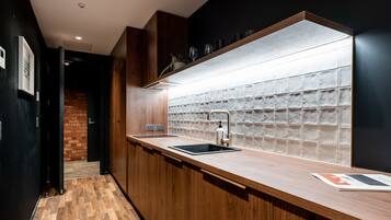 A modern kitchen with a wooden countertop, a built-in sink, and a backsplash of square tiles.