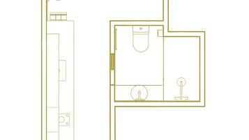 Plànol d'una habitació d'hotel amb un llit gran, escriptori, cadira, armari i bany.