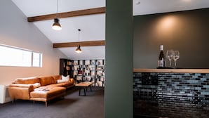 Een moderne woonkamer met een leren bank, een salontafel en een boekenkast vol boeken.