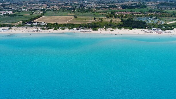 An aerial view of a coastal area with a beach, a sports field, and a residential zone. - 3180 Appartamento Raffaella by Barbarhouse (Gallipoli)