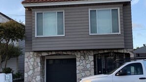 Una casa de dos pisos con fachada de piedra y techo de tejas.