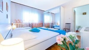A modern bedroom with a large bed, a mirror, and a view of a balcony. - Stunning 3-bed House in Orebic (Orebic)