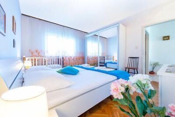A modern bedroom with a large bed, a mirror, and a view of a balcony. - Stunning 3-bed House in Orebic (Orebic)
