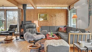 Un salon chaleureux avec une cheminée, des fauteuils en cuir, un canapé et une table basse.