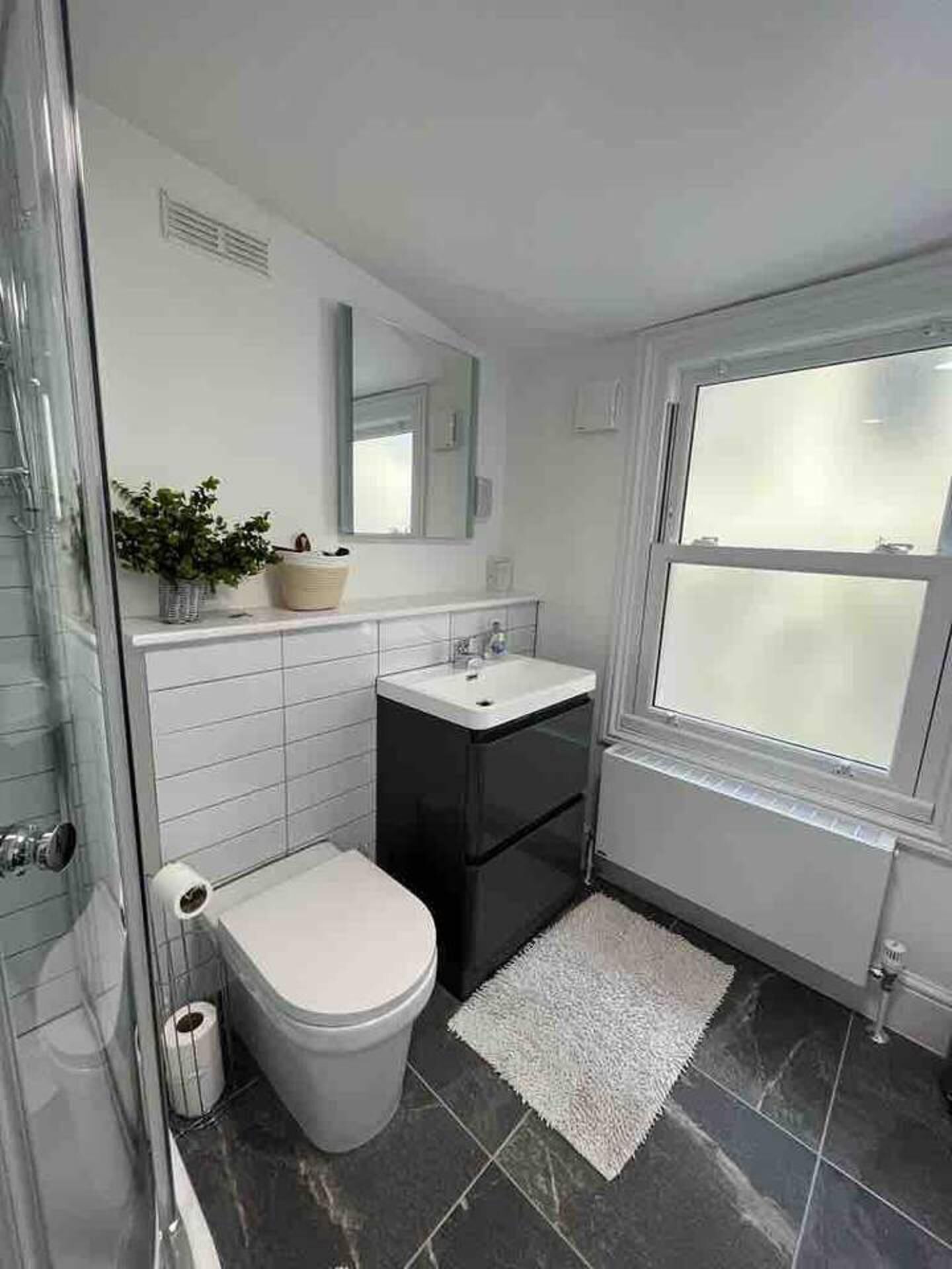 Un bagno con il water, un lavandino e uno specchio.