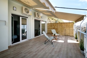 Relax on the balcony with comfortable seating and a retractable awning for shade.