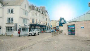 Eine Kopfsteinpflasterstraße mit einem weißen Gebäude, das ein Schild für "The Navy Inn" zeigt.