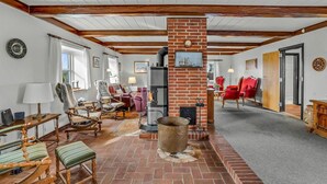 A cozy living room with a brick fireplace, wooden beams, and comfortable seating. - 7 bedroom stunning home in Outrup (Outrup)