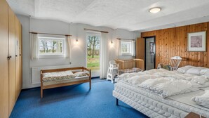 A bedroom with a bunk bed, a single bed, a window, a door, and a view of the outdoors. - 7 bedroom stunning home in Outrup (Outrup)