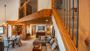 Un amplio espacio habitable con una escalera de madera, un comedor y una cocina.