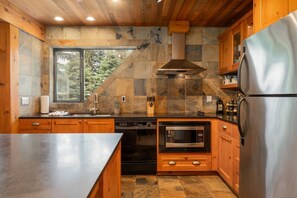 Enjoy cooking in this kitchen with a large island, stainless steel appliances, and wooden cabinetry.