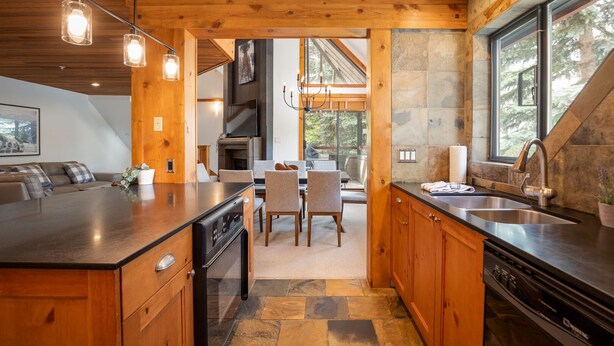 Una cocina moderna con armarios de madera, una isla grande y un protector contra salpicaduras de piedra.