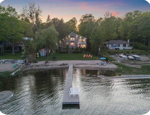 A lakeside property with a dock, a house, and a small boat.