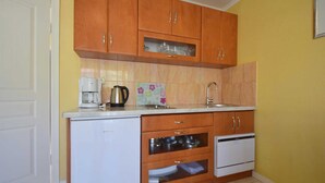 A compact kitchen with wooden cabinets, a built-in oven, and a sink.