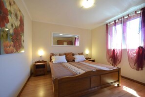 Relax in a cozy bedroom with a comfortable bed, large mirror, and soft window treatments.