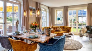 Een eetgedeelte met een tafel voor vier personen, een bank en uitzicht op de omgeving.