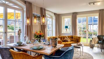 A dining area with a table set for four, a sofa, and a view of the outdoors.