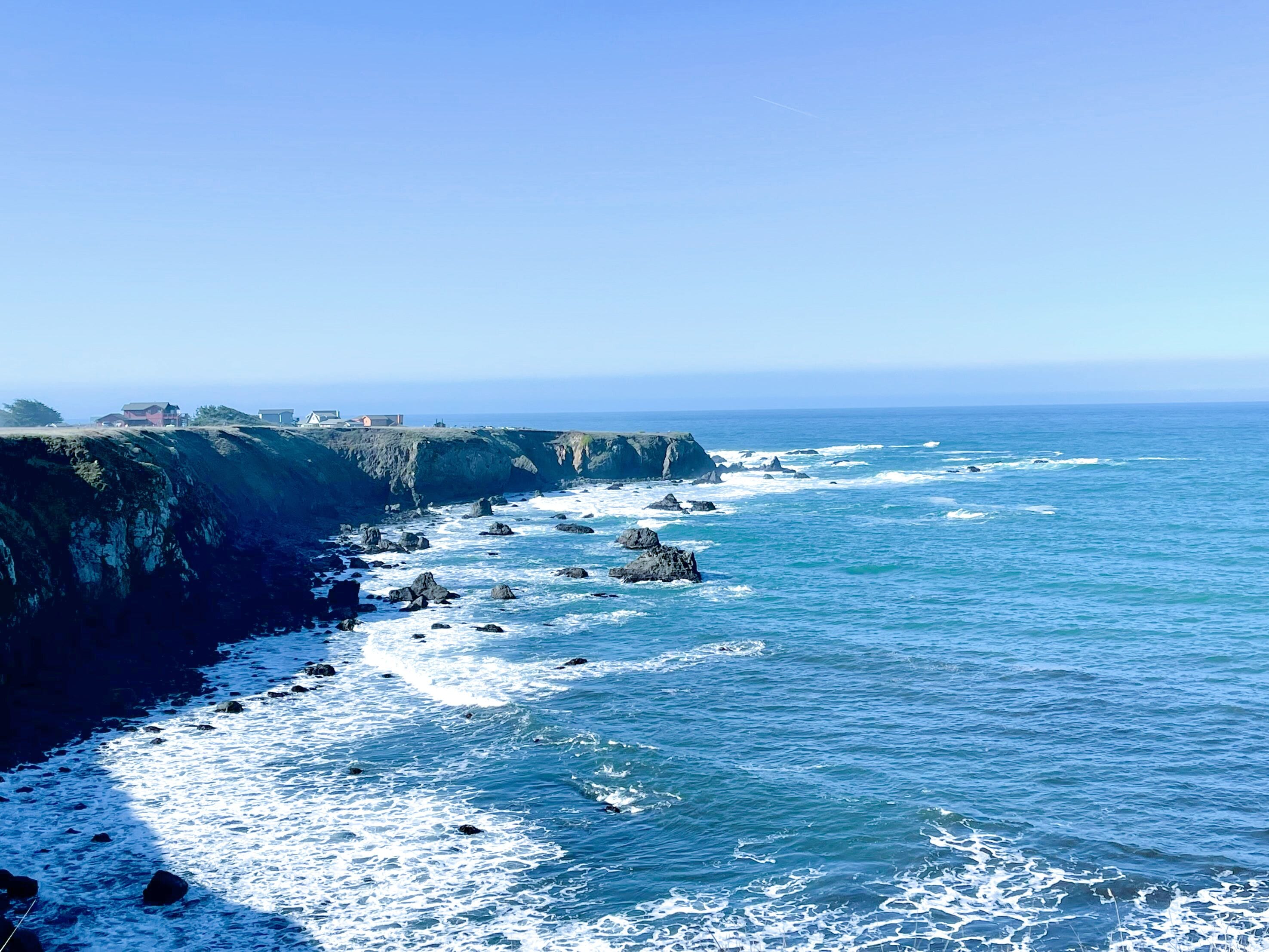 A coastal landscape with rocky cliffs and the ocean.