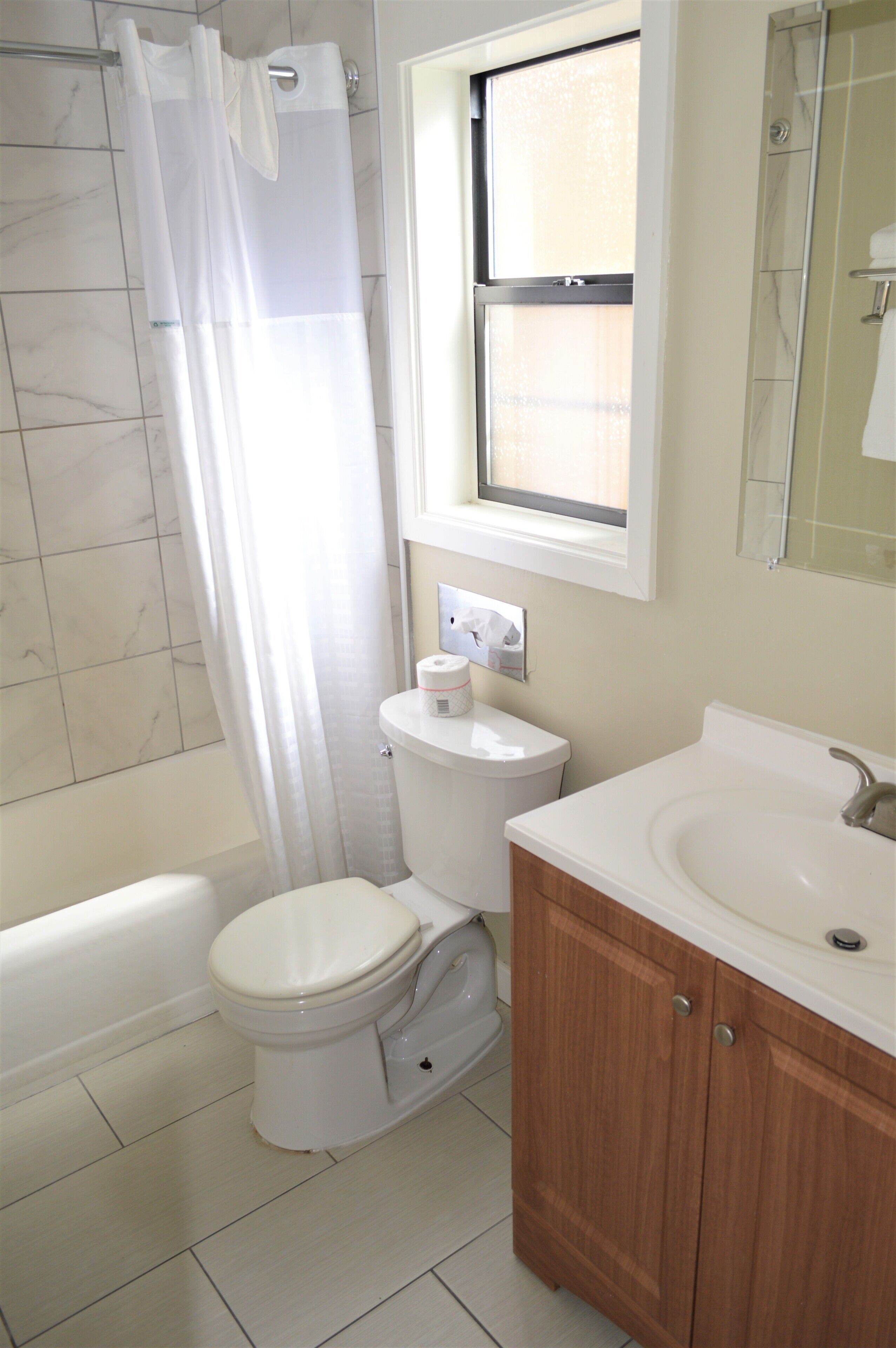 A bathroom with a toilet, a sink, and a shower area.