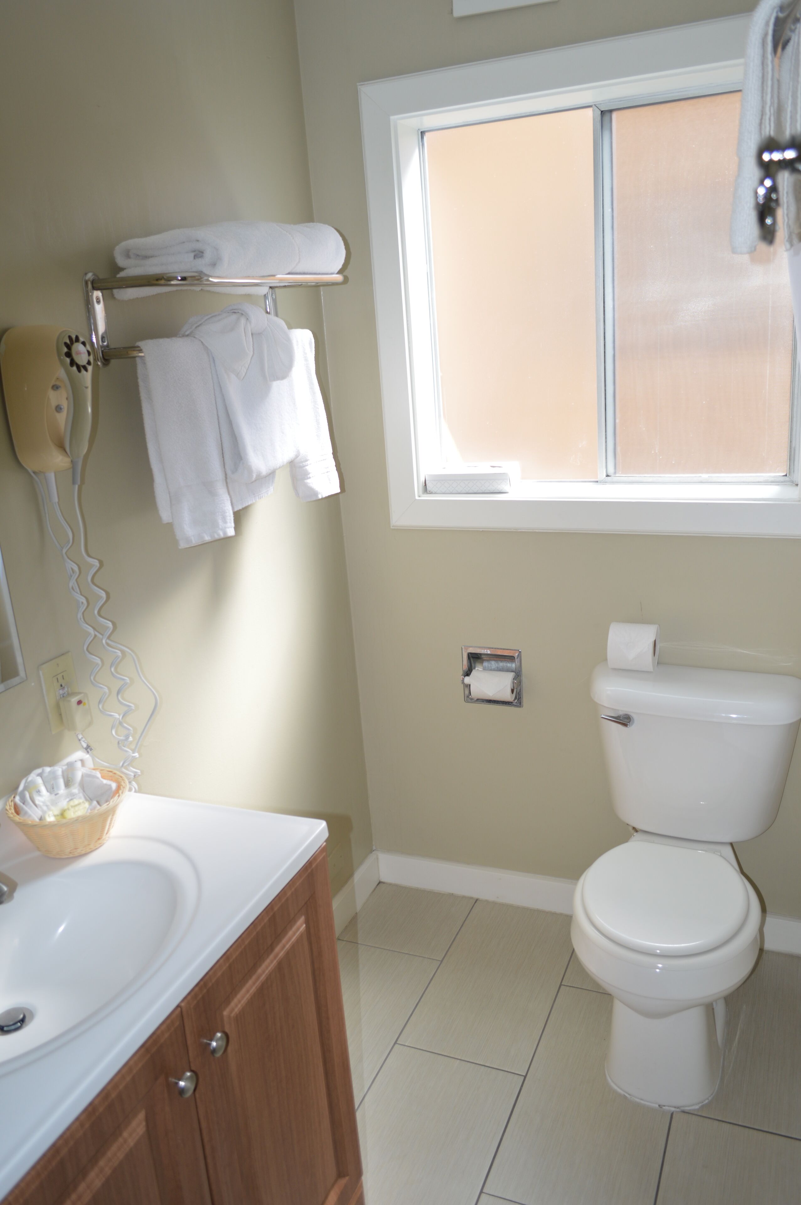 Une salle de bain équipée de toilettes, d’un lavabo et d’un porte-serviettes.