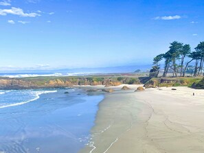 A beach with a clear view of the ocean, sandy shore, and distant mountains. - Studio 9 Fort Bragg, LLC. (Fort Bragg)