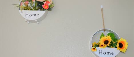 Dos letreros montados en la pared con la palabra 'Home' y adornos florales.