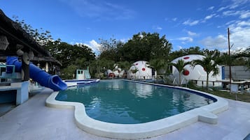 Relax by the pool surrounded by spherical structures and lush greenery.