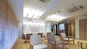 A modern waiting area with wooden furniture, a vending machine, and a reception desk. - Far East Village Hotel Tokyo, Asakusa (Tokyo)