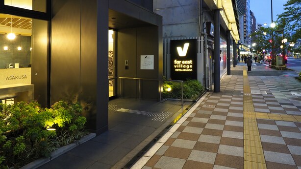 A hotel entrance with a sign for Far East Village Hotel Asakusa, a modern building with a dark facade, and a checkered sidewalk. - Far East Village Hotel Tokyo, Asakusa (Tokyo)
