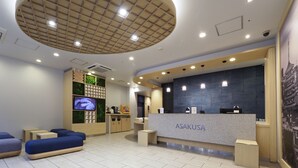 A modern reception area with a counter labeled "ASAKUSA," a television, and seating arrangements. - Far East Village Hotel Tokyo, Asakusa (Tokyo)