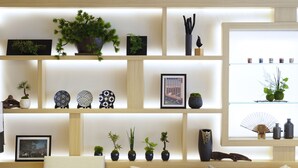 A modern living room with a wooden sofa, a coffee table, and a bookshelf filled with decorative items and plants. - Far East Village Hotel Tokyo, Asakusa (Tokyo)