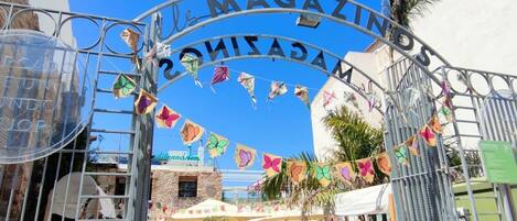 Un arco metálico con la palabra 'MAGAZINES' escrita, rodeado de coloridas decoraciones de mariposas.