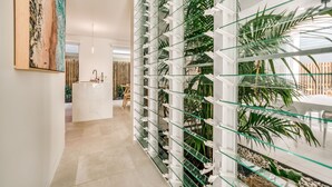 A modern interior with a glass wall displaying plants, a reception desk, and a dining area.