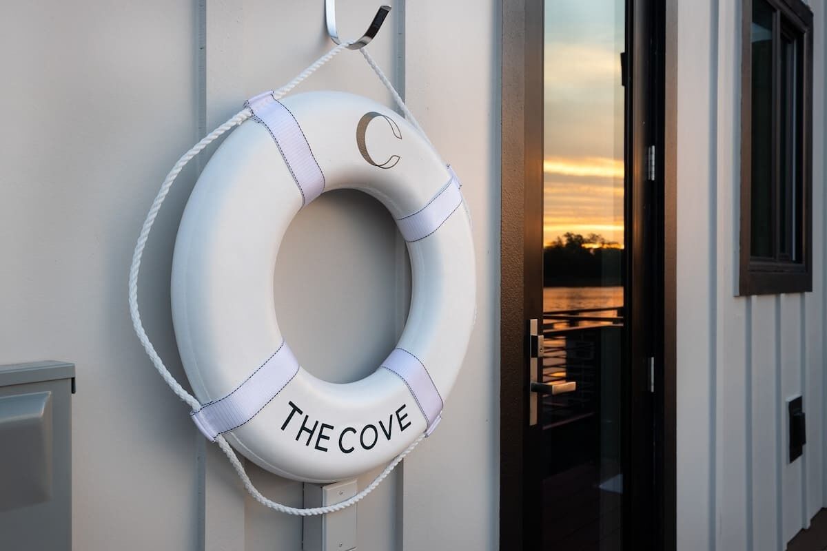 A lifebuoy with 'THE COVE' text on a building wall.