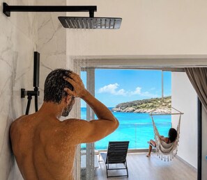 En mand i brusebad med udsigt til en kvinde i hængekøje ved en pool.