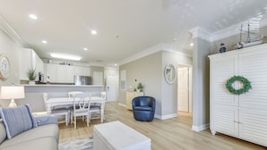 Uma sala de estar moderna com sofá, mesa de centro e um espaço de refeições com cadeiras e mesa.