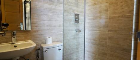 Ein Badezimmer mit Waschbecken, Toilette und Duschkabine.