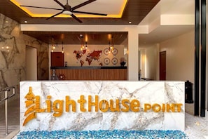 A reception area with a marble counter, a world map, and a ceiling fan.