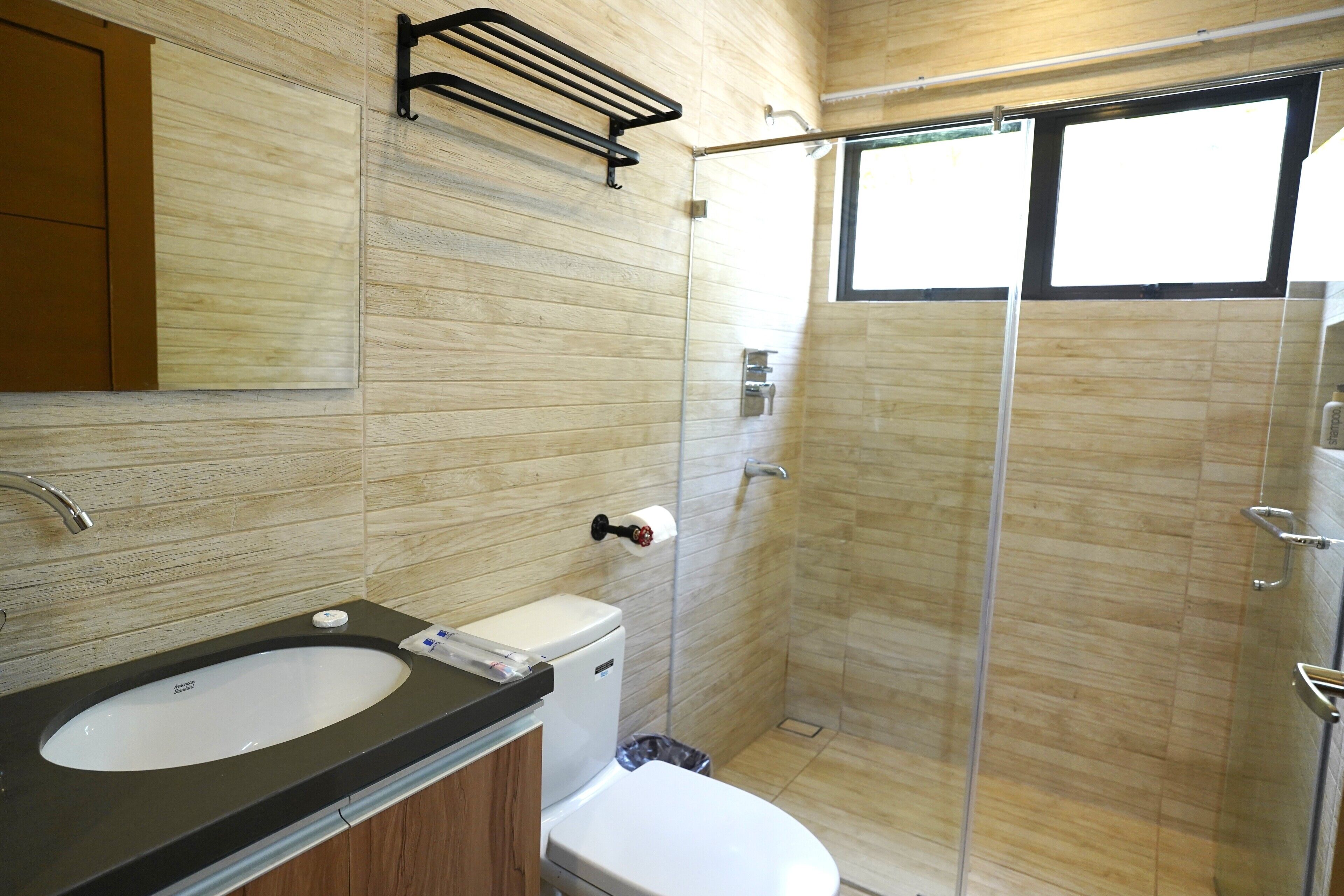 Un baño con lavamanos, inodoro y ducha.