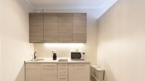 A compact kitchen with a microwave, sink, and cabinets. - S.Maria Valle Apartment 3 (Milano)