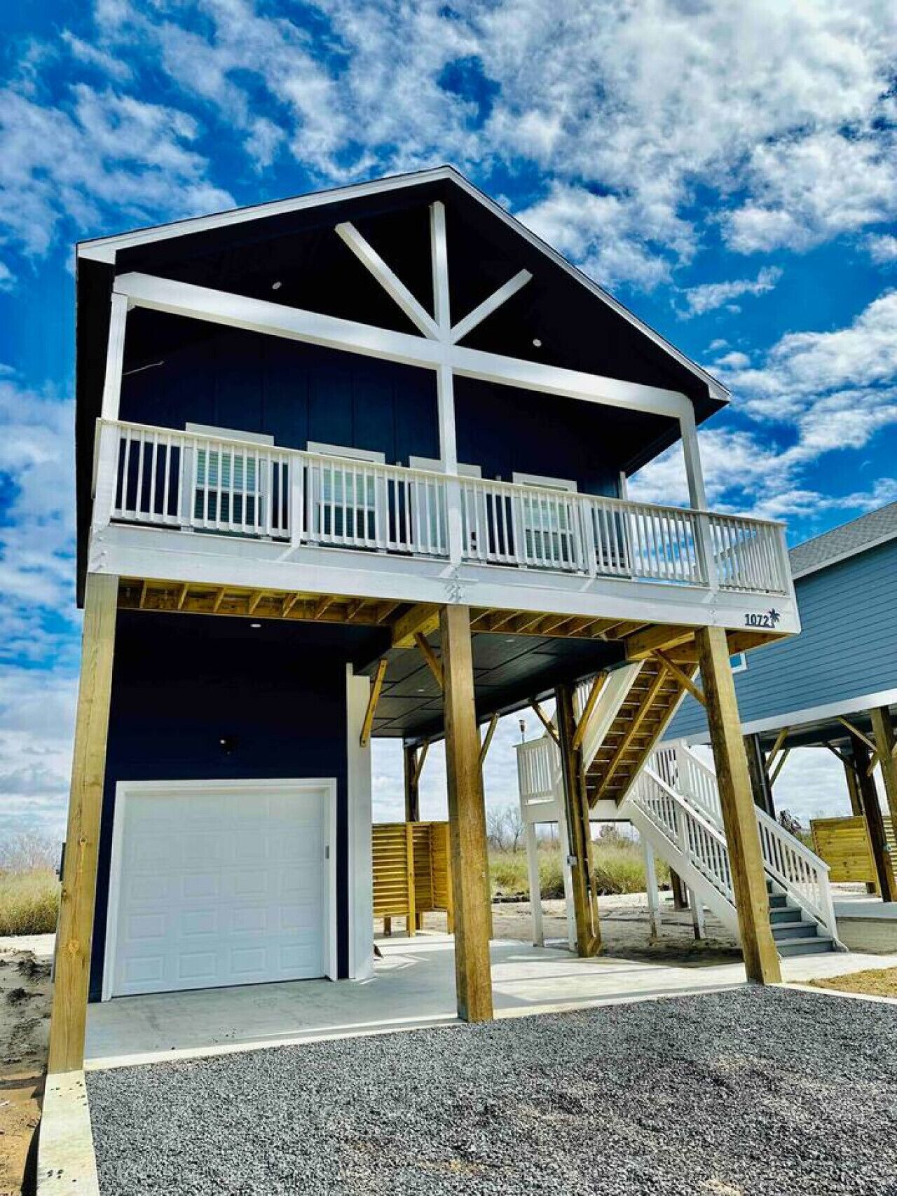 A two-story building with a balcony, a garage, and a staircase.