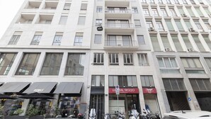 Un edificio de varios pisos con una planta baja comercial que presenta un restaurante llamado 'Lu D'al Trozzo' y un escaparate con un letrero que dice 'BOWLS'.