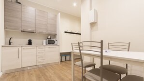 Una cocina moderna con armarios de madera, un microondas y una mesa de comedor con sillas.