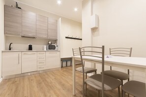 Una cocina moderna con armarios de madera, un microondas y una mesa de comedor con sillas.