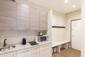 Une cuisine moderne équipée d’un évier, de placards, d’un four à micro-ondes et d’un banc.
