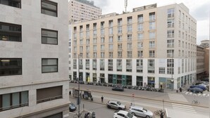 A multi-story building with a modern architectural style, featuring a large ground-level entrance and a series of windows. - Missori Apartment 2  (Milano)