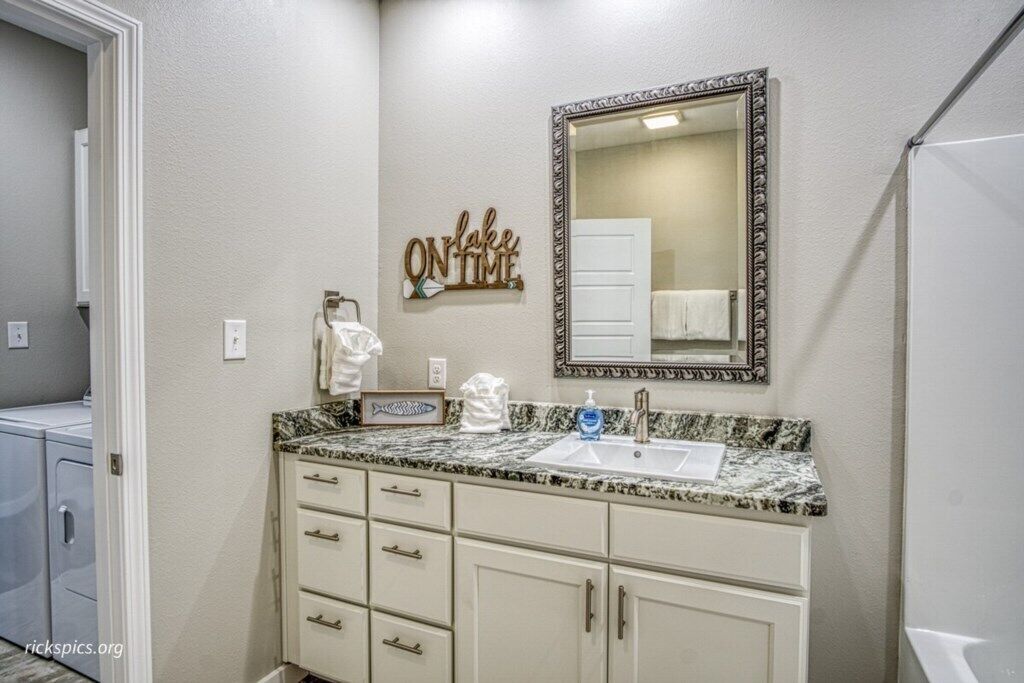 A bathroom with a sink, mirror, and towel rack.